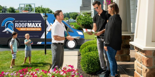 Alt text: Roof Maxx dealer explains restoration to homeowners.
